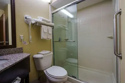 a bathroom with a toilet and a glass shower at Quality Inn I-75 West Chester-North Cincinnati in West Chester