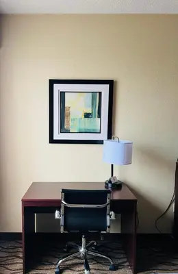 a desk with a chair and a lamp on it at Quality Inn I-75 West Chester-North Cincinnati in West Chester
