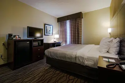 a hotel room with a bed and a flat screen tv at Quality Inn I-75 West Chester-North Cincinnati in West Chester