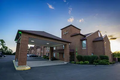 a large brick building with a clock tower in a parking lot at Quality Inn I-75 West Chester-North Cincinnati in West Chester