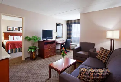 a hotel room with a bed and a living room at Holiday Inn Cincinnati-Eastgate by IHG in Eastgate