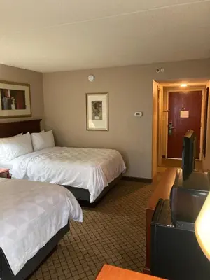 a hotel room with two beds and a flat screen tv at Holiday Inn Cincinnati-Eastgate by IHG in Eastgate