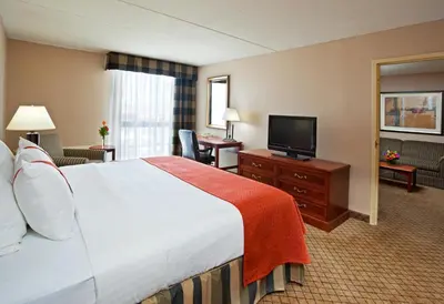 a hotel room with a bed and a flat screen tv at Holiday Inn Cincinnati-Eastgate by IHG in Eastgate