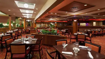 a dining room with tables and chairs in a restaurant at Holiday Inn Cincinnati Airport by IHG in Erlanger