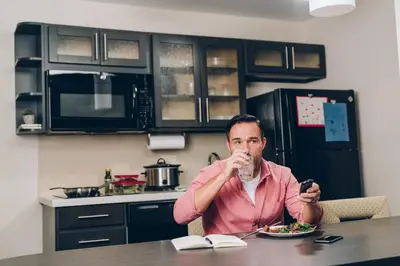 a man sitting at a table eating a plate of food at Candlewood Suites Washington North by IHG in Washington