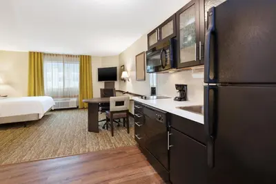 a hotel room with a kitchen and a bedroom at Candlewood Suites Washington North by IHG in Washington