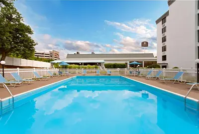 a swimming pool with chairs and a building at DoubleTree by Hilton Washington Meadow Lands Casino Area in Washington