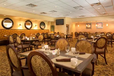 a restaurant with tables and chairs in a room at DoubleTree by Hilton Washington Meadow Lands Casino Area in Washington