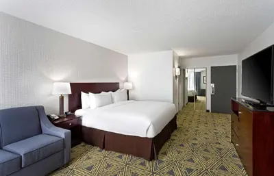 a bedroom with a bed and a chair and a television at DoubleTree by Hilton Washington Meadow Lands Casino Area in Washington