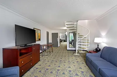 a living room with a blue couch and a tv at DoubleTree by Hilton Washington Meadow Lands Casino Area in Washington