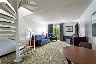 a lobby with a staircase and a table and chairs at DoubleTree by Hilton Washington Meadow Lands Casino Area in Washington