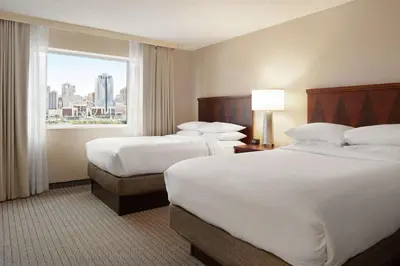 a hotel room with two beds and a window at Embassy Suites Cincinnati - RiverCenter in Covington