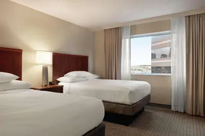 a hotel room with two beds and a window at Embassy Suites Cincinnati - RiverCenter in Covington
