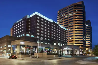 a hotel with two tall buildings at night at Embassy Suites Cincinnati - RiverCenter in Covington