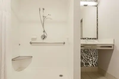 a white bathroom with a shower and a sink at Hilton Garden Inn Cleveland/Twinsburg in Twinsburg