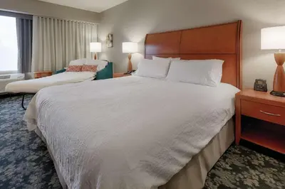 a hotel room with a large bed with white sheets at Hilton Garden Inn Cleveland/Twinsburg in Twinsburg