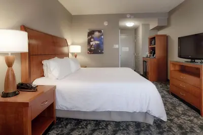 a hotel room with a bed and a flat screen tv at Hilton Garden Inn Cleveland/Twinsburg in Twinsburg