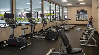 a gym with a row of treadmills and machines at Holiday Inn Cleveland - South Independence by IHG in Independence