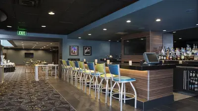 a bar with yellow and blue chairs in a restaurant at Holiday Inn Cleveland - South Independence by IHG in Independence