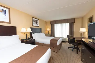 a hotel room with two beds and a flat screen tv at Holiday Inn Cleveland - South Independence by IHG in Independence