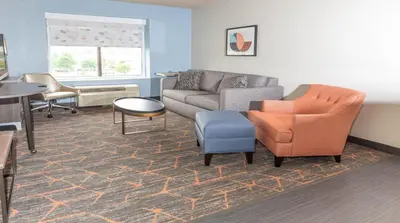 a living room with a couch and chairs and a table at Holiday Inn Cleveland - South Independence by IHG in Independence
