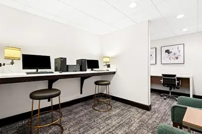 a waiting room with a desk with a computer and two stools at Staybridge Suites - Cincinnati North by IHG in West Chester