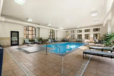 a swimming pool in a large room with a building at Staybridge Suites - Cincinnati North by IHG in West Chester