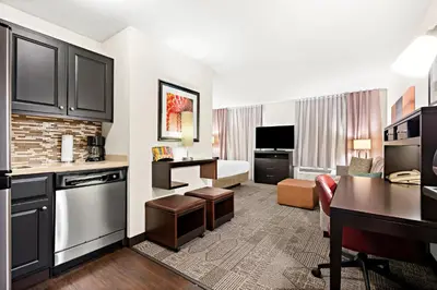 a hotel suite with a kitchen and a living room at Staybridge Suites - Cincinnati North by IHG in West Chester