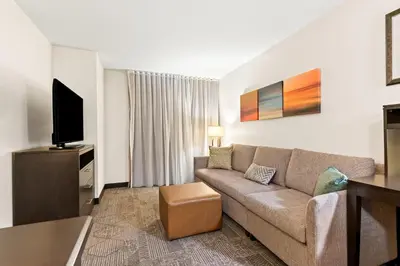 a living room with a couch and a flat screen tv at Staybridge Suites - Cincinnati North by IHG in West Chester