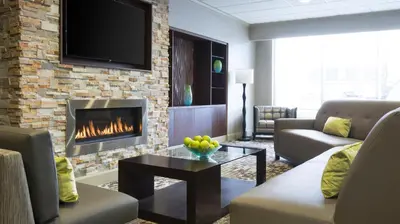 a living room with a fireplace and a tv at Holiday Inn Cincinnati-Riverfront by IHG in Covington