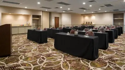 a conference room with tables and chairs on a carpet at Holiday Inn Cincinnati-Riverfront by IHG in Covington