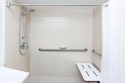 a bathroom with a shower with a toilet and a sink at Sonesta Simply Suites Cleveland North Olmsted Airport in North Olmsted
