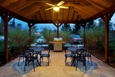 a patio with tables and chairs and a ceiling fan at Sonesta Simply Suites Cleveland North Olmsted Airport in North Olmsted