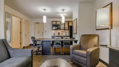 a living room and kitchen with a table and chairs at Sonesta Simply Suites Cleveland North Olmsted Airport in North Olmsted