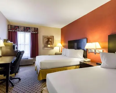 a hotel room with two beds and a desk at Quality Inn & Suites Oakwood Village - Cleveland South in Oakwood