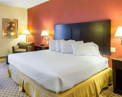a large white bed in a hotel room at Quality Inn & Suites Oakwood Village - Cleveland South in Oakwood