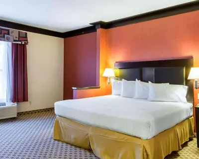 a large white bed in a hotel room at Quality Inn & Suites Oakwood Village - Cleveland South in Oakwood