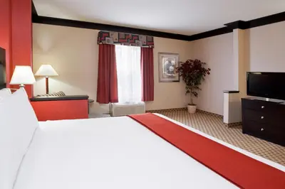 a hotel room with a large bed and a flat screen tv at Quality Inn & Suites Oakwood Village - Cleveland South in Oakwood