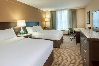 a hotel room with two beds and a desk at Best Western Plus Strongsville Cleveland in Strongsville