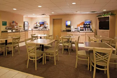 a restaurant with tables and chairs and a bar at Holiday Inn Express Vermilion by IHG in Vermilion