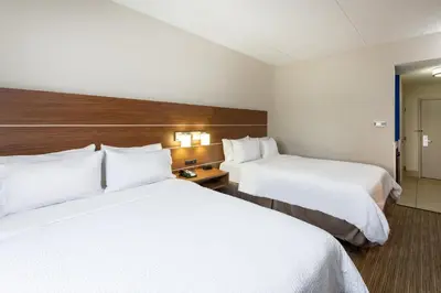 two beds in a hotel room with white sheets at Holiday Inn Express Vermilion by IHG in Vermilion