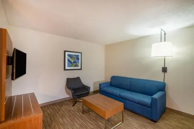 a living room with a blue couch and a chair at Holiday Inn Express Vermilion by IHG in Vermilion