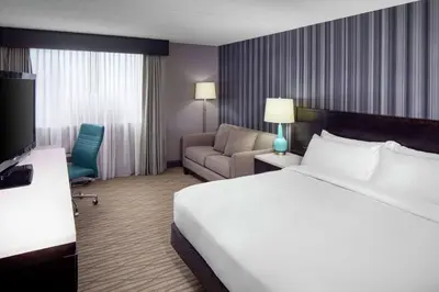 a hotel room with a bed and a chair at Wyndham Garden Westlake in Westlake