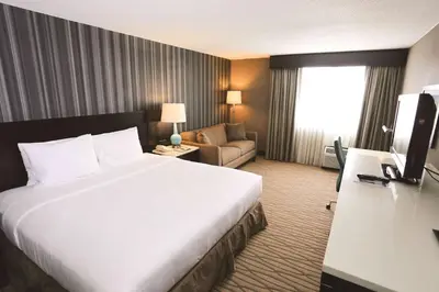 a hotel room with a large bed and a couch at Wyndham Garden Westlake in Westlake