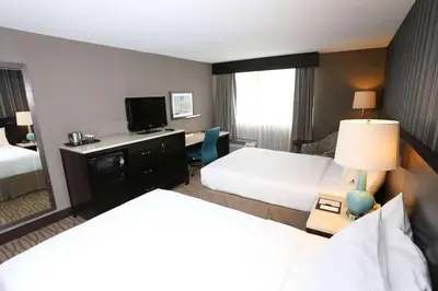 a hotel room with two beds and a television at Wyndham Garden Westlake in Westlake
