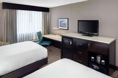 a hotel room with a bed and a desk with a television at Wyndham Garden Westlake in Westlake