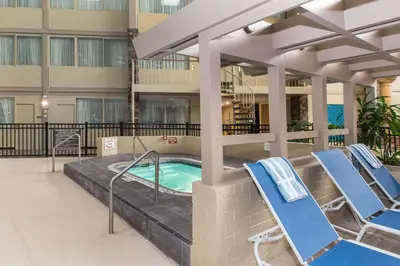 a pool in a building with two lounge chairs at Wyndham Garden Westlake in Westlake