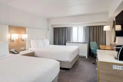 a hotel room with two beds and a desk at Sonesta Columbus Downtown in Columbus