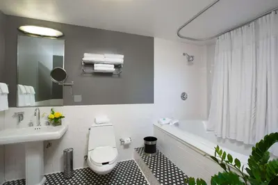 a bathroom with a tub and a toilet and a sink at Sonesta Columbus Downtown in Columbus