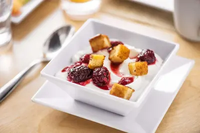 a white bowl of food with berries and whipped cream at Hyatt Place Cleveland/Lyndhurst/Legacy Village in Lyndhurst